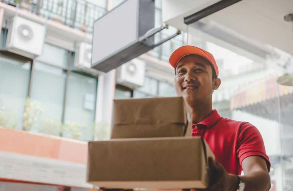 Why Ecommerce Businesses Should Invest In Better Customer Service in 2022 - Stikky Media Delivery person providing customer service with a smile
